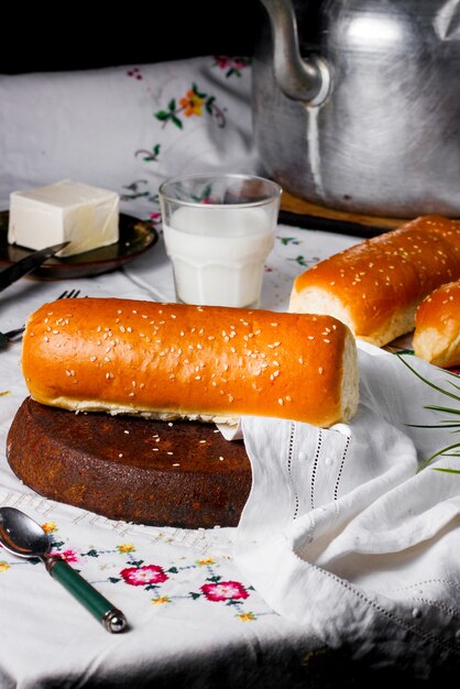 Langes Gebäckbrötchen mit Sesamstreuseln, serviert mit Milch