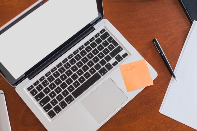 Laptop-Blätter und Stift auf dem Tisch platziert