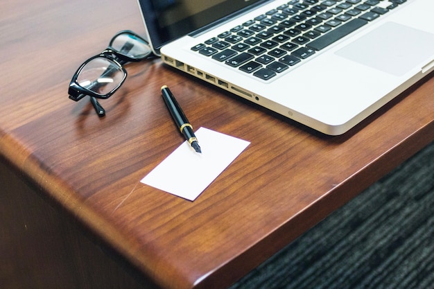 Laptop Gläser und Stift auf Tisch gelegt