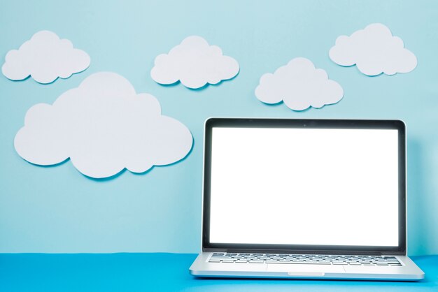 Laptop in der Nähe von Papier Wolken