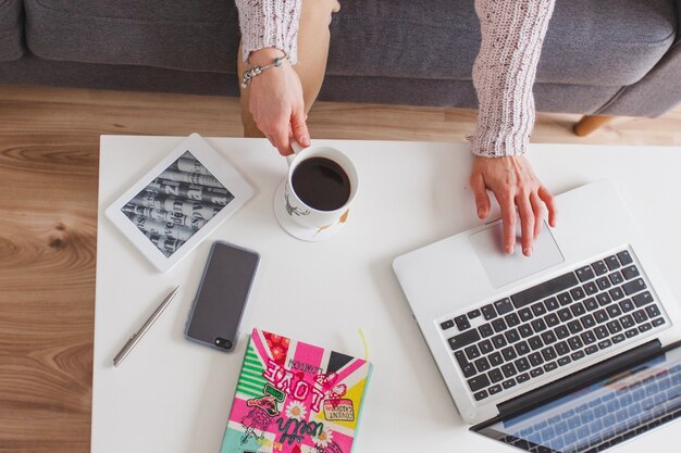 Laptop, Kaffee und Smartphone auf Tischansicht