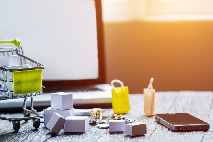 Kostenlose Foto laptop leere bildschirm und hopping warenkorb voller geschenke mit copyspace, online-shopping-konzept.