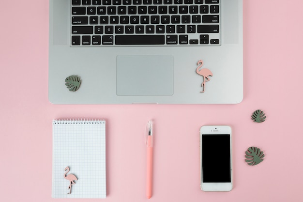 Laptop mit Smartphone und kleinen Flamingos