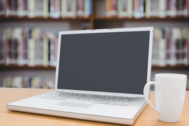 Laptop und eine Tasse mit unscharfen Hintergrund