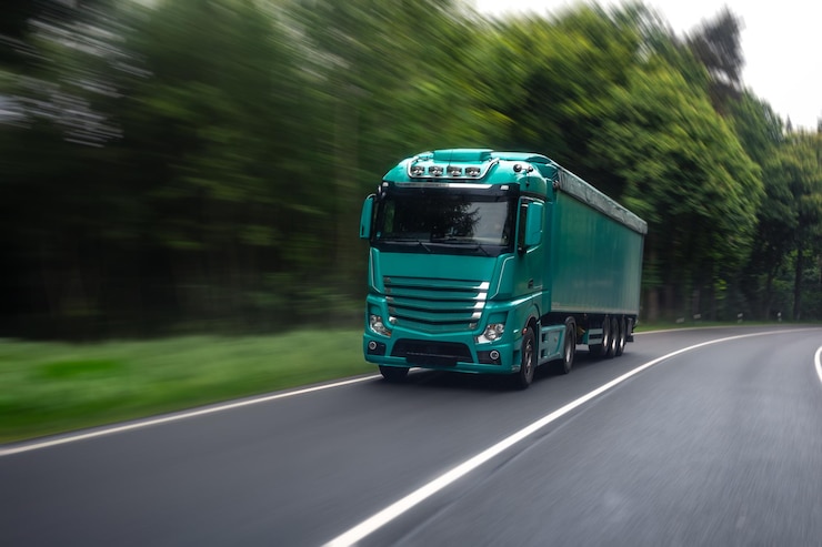 Kostenlose Foto lastwagen auf einer waldstraße bewegter lkw-frachtverkehrsszene