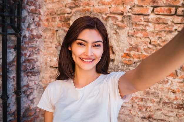 Lateinamerikanische Frau, die ein Selfie nimmt.