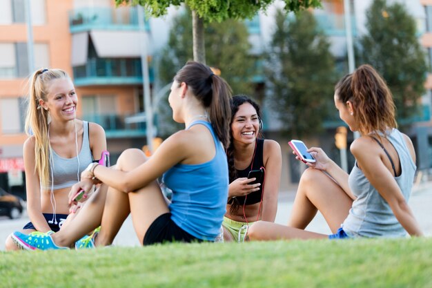 Laufende Mädchen, die Spaß im Park mit Handy haben.