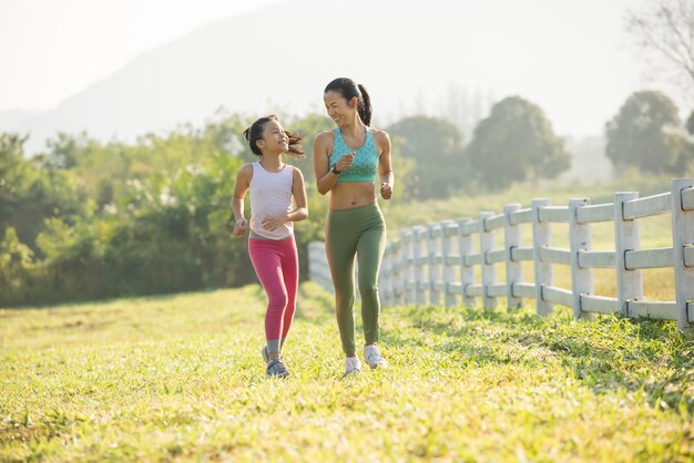 Laufschuhläuferfrau, die Schnürsenkel für den Herbstlauf im Waldpark bindet. Läufer, die Laufschuhe ausprobieren, bereiten sich auf den Lauf vor. Joggen Mädchen Übung Motivation Gesundheit und Fitness. warmes Sonnenlicht flackern.