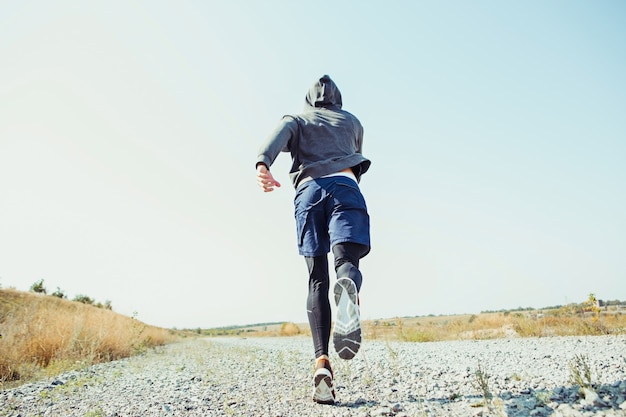 Laufsport. Mannläufer, der im Freien in der landschaftlich reizvollen Natur sprintet.