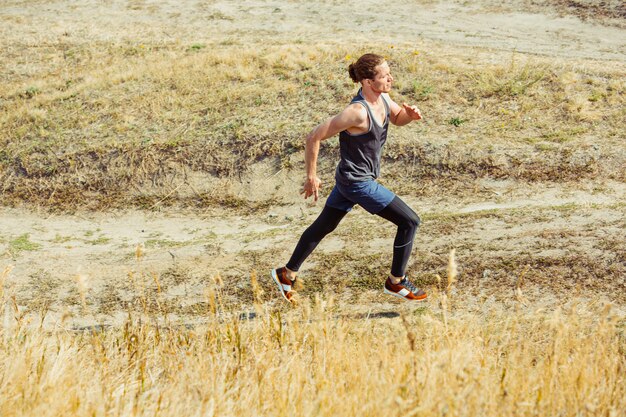 Laufsport. Mannläufer, der im Freien in der szenischen Natur sprintet. Fit muskulöses männliches Athletentraining für Marathonlauf.