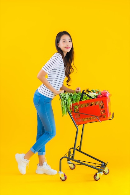 Lebensmitteleinkauf der jungen asiatischen Frau vom Supermarkt und vom Wagen