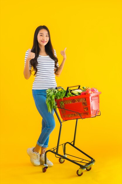 Lebensmitteleinkauf der jungen asiatischen Frau vom Supermarkt und vom Wagen