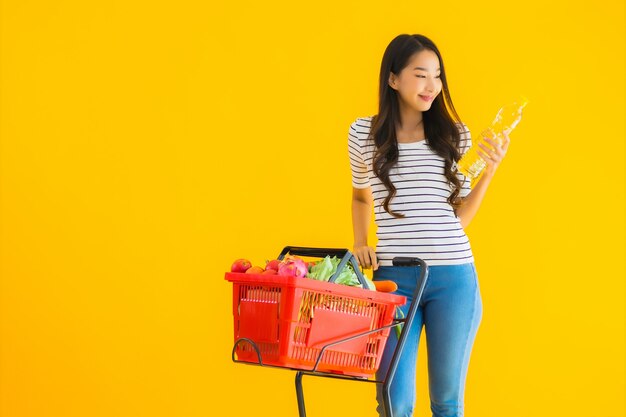 Lebensmitteleinkauf der jungen asiatischen Frau vom Supermarkt und vom Wagen