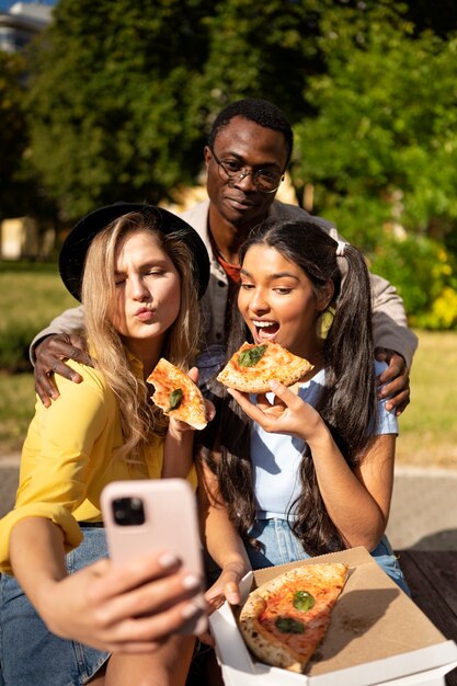 Lebensstil von Freunden, die im Freien Pizza essen