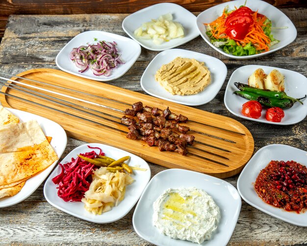 Leber Kebab Hummus Gurken grüner Salat Pfeffer Tomaten Zwiebel Lavash Seitenansicht