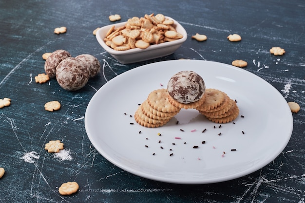 Kostenloses Foto lebkuchen und cracker in einem weißen teller auf blau.