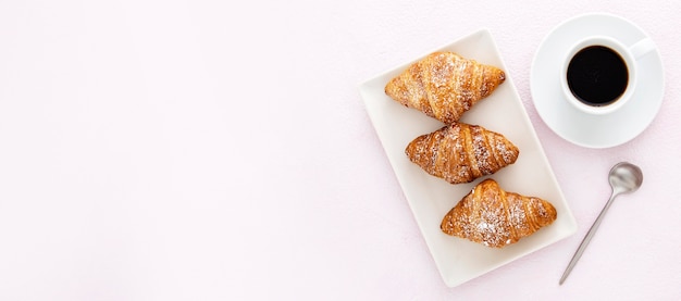 Leckere Croissants mit Kaffee und Löffel