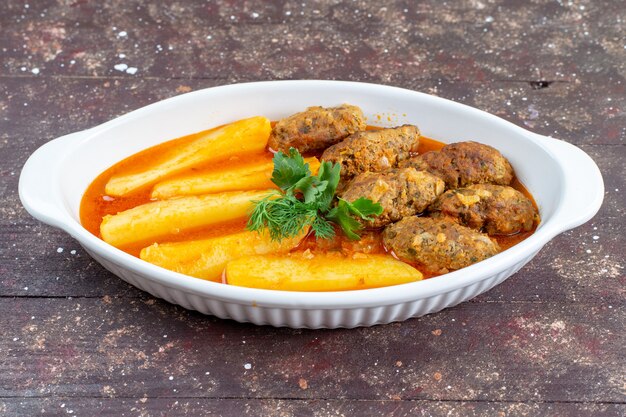 leckere Fleischkoteletts gekocht zusammen mit Kartoffeln und Sauce in Teller auf braun rustikalen Schreibtisch Fleisch Kartoffel Gericht Mahlzeit Abendessen