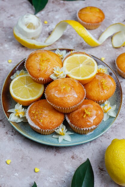 Leckere frisch gebackene hausgemachte Zitronenmuffins mit Zitronen auf einem Teller auf Licht