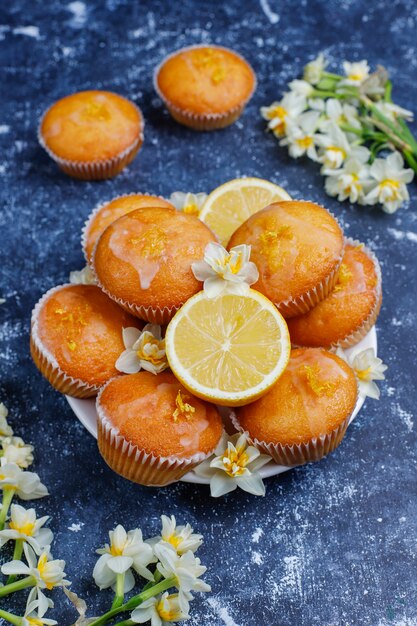 Leckere frisch gebackene hausgemachte Zitronenmuffins mit Zitronen auf einem Teller