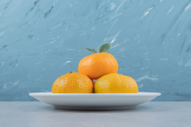 Leckere frische Mandarinen auf weißem Teller.