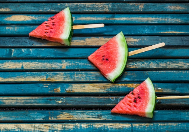 Leckere frische wassermelone. eis mit wassermelone. köstliche wassermelone auf einem blauen hölzernen hintergrund. nahansicht. platz für text.