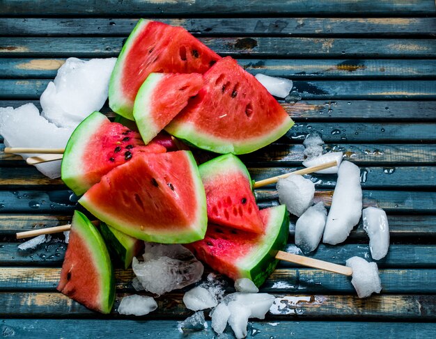 Leckere frische Wassermelone. Eis mit Wassermelone. Köstliche Wassermelone auf einem blauen hölzernen Hintergrund. Nahansicht.