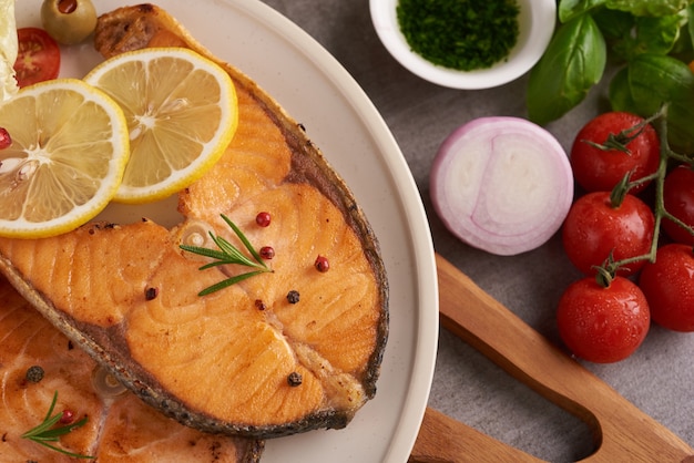 Leckere gekochte Lachsfischfilets. Gegrilltes Lachsfischfilet und frischer grüner Salatgemüsetomatensalat. Ausgewogenes Ernährungskonzept für eine saubere, flexible mediterrane Ernährung.