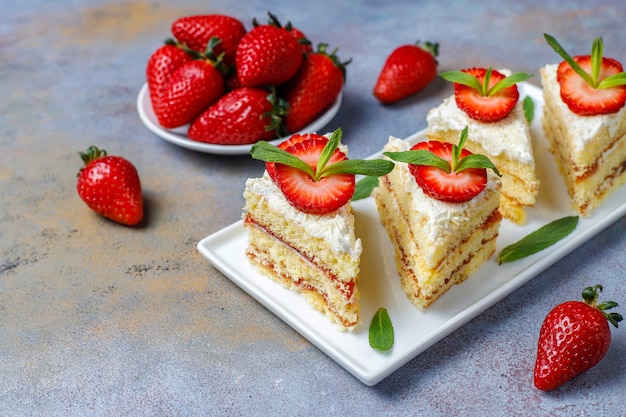 Kostenloses Foto leckere hausgemachte erdbeerkuchenscheiben mit sahne und frischen erdbeeren, draufsicht