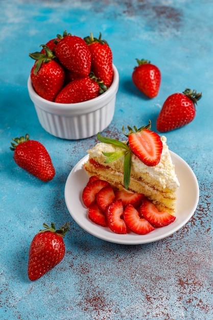 Leckere hausgemachte Erdbeerkuchenscheiben mit Sahne und frischen Erdbeeren