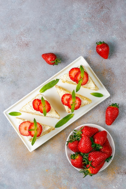 Leckere hausgemachte Erdbeerkuchenscheiben mit Sahne und frischen Erdbeeren