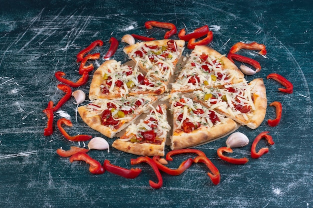 Kostenloses Foto leckere käsige pizza auf blau mit frischem gemüse.