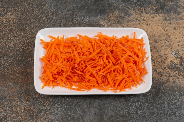 Leckere Karotten julienned auf weißem Teller.