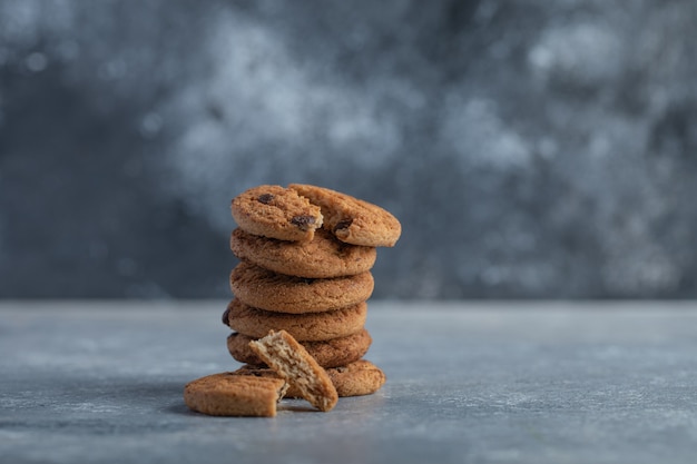 Leckere Kekse mit Schokolade auf grauem Hintergrund.