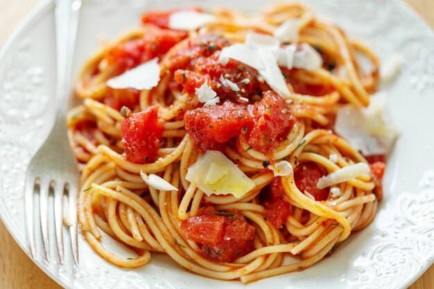 Leckere klassische italienische Pasta mit Tomatensauce und Käse auf dem Teller. Nahansicht.