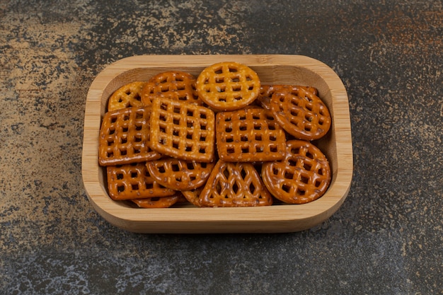 Leckere knusprige Cracker auf Holzplatte.