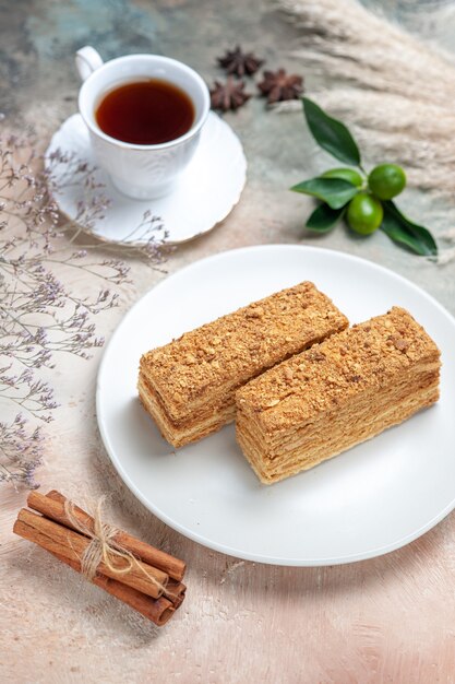 leckere Kuchenstücke mit Tee auf grau