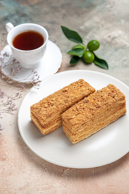 Kostenloses Foto leckere kuchenstücke mit tee auf grau