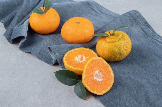 Leckere Mandarinenfrüchte auf blauem Tuch
