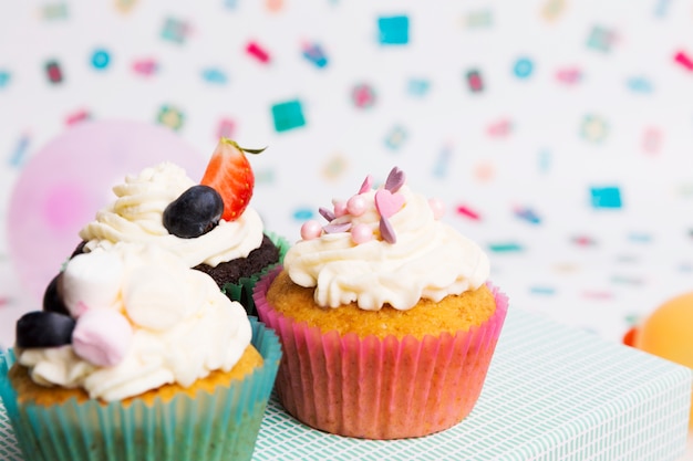 Leckere Muffins in der Nähe von hellen Ballons