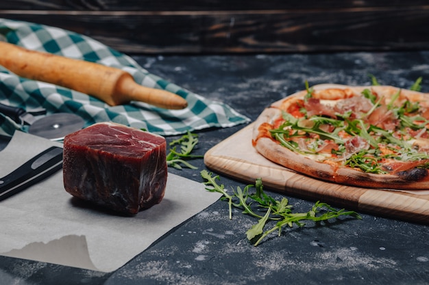 Leckere neapolitanische Pizza auf einer Tafel mit verschiedenen Zutaten, freier Platz für Text