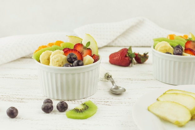 Leckere Obstsalate, umgeben von Obst