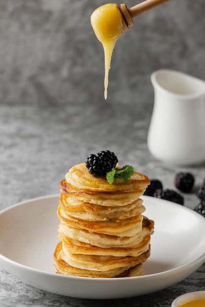 Leckere Pfannkuchen mit Brombeeren und Honig