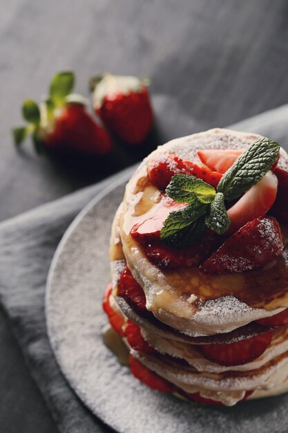 Leckere Pfannkuchen mit Erdbeeren und Honig