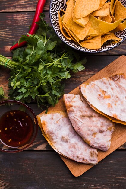 Leckere Pita in der Nähe von Kräutern unter Nachos mit Sauce