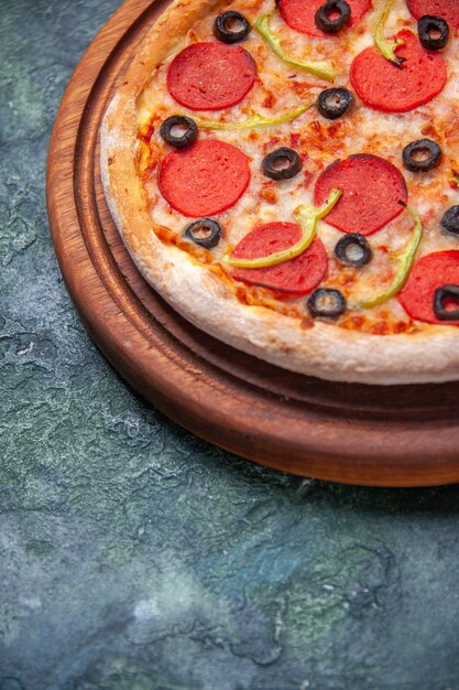 Leckere Pizza auf Holzbrett auf der linken Seite auf isolierter dunkler Oberfläche mit freiem Platz in Nahaufnahme