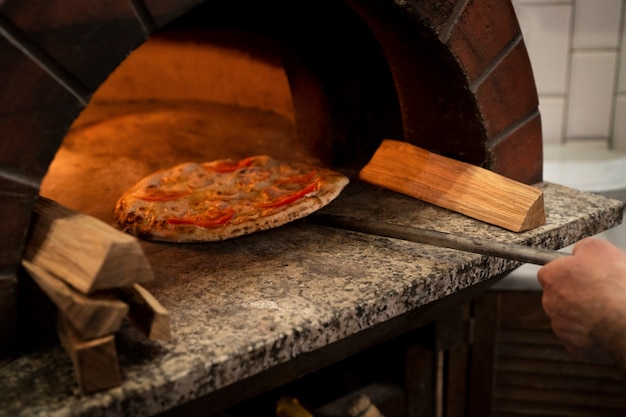 Kostenloses Foto leckere pizza backen mit holzofen