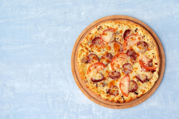 Leckere Pizza mit Würstchen auf grauem Hintergrund