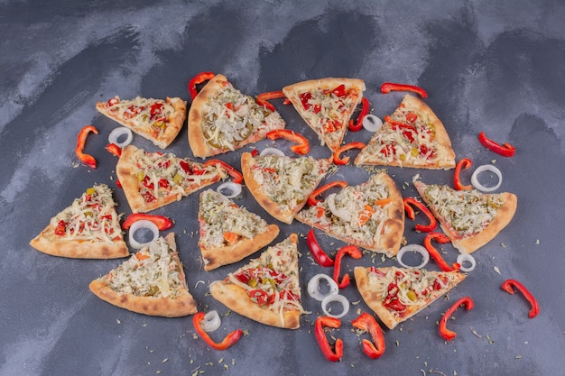 Leckere pizzastücke auf blau mit zwiebelringen und pfeffer.