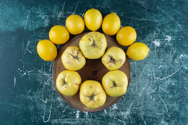 Kostenloses Foto leckere quitten und zitronen auf marmortisch.